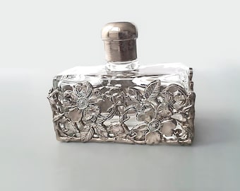 Vintage glass and pewter flowers overlay perfume bottles