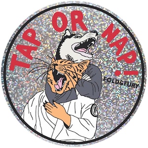 May include: A circular holographic sticker featuring a graphic illustration of a husky and a tabby cat in a grappling hold. The text TAP OR NAP! is printed in red above the animals, with FOLD&FURY printed in black on the right side of the sticker.