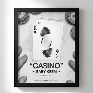 May include: Black and white framed poster featuring a playing card with a portrait of a person, and the text "CASINO" and "BABY KEEM". The poster includes casino chips and the text "BOOMAN.CO".
