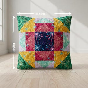 Könnte beinhalten: Quadratisches Zierkissen, 45,7 cm x 45,7 cm, mit einem Patchwork-Design. Die Mitte zeigt ein marineblaues Quadrat mit einem Feuerwerksmuster. Die umgebenden Quadrate sind in Rosa-, Gelb-, Grün- und Lavendeltönen gehalten.