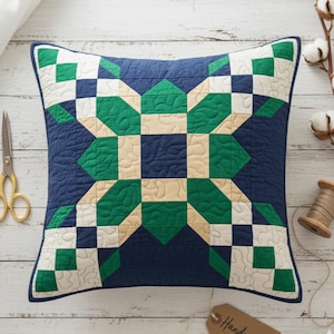 May include: Square decorative pillow with a navy blue background and a starburst pattern in green, cream, and white. The pillow has a quilted texture and a navy blue border. The pillow is approximately 18 inches square.