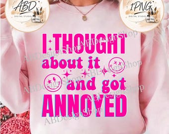 May include: A light pink sweatshirt featuring the bold, bright pink text I THOUGHT about it and got ANNOYED. The design includes two circular smiley face icons with lightning bolt and cross eyes, surrounded by small four-pointed star graphics.