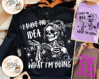 May include: A black sweatshirt featuring a white graphic of a skeleton wearing sunglasses with the text I HAVE NO IDEA WHAT I'M DOING. Two smaller images show the same design on a light purple t-shirt and a brown t-shirt with pink text.