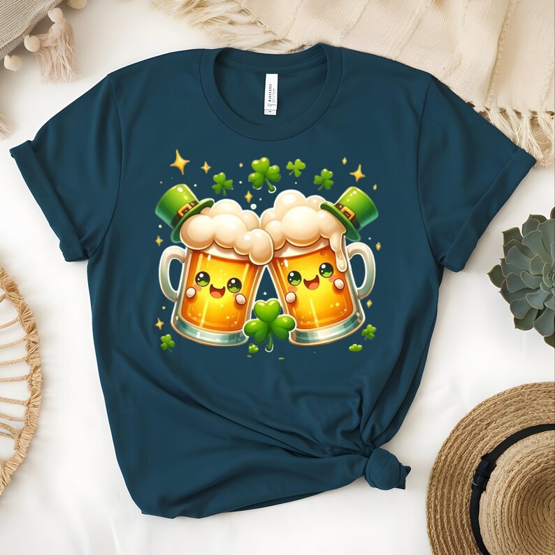 Peut inclure: T-shirt bleu marine avec un motif de la Saint-Patrick. Le graphisme repr&eacute;sente deux chopes de bi&egrave;re de dessin anim&eacute; qui s'entrechoquent, chacune avec un chapeau de lutin vert et un visage souriant. Des tr&egrave;fles et des &eacute;toiles verts sont dispers&eacute;s.