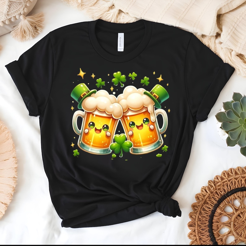 Peut inclure: T-shirt noir avec un motif de la Saint-Patrick. Le graphisme repr&eacute;sente deux chopes de bi&egrave;re de dessin anim&eacute; avec des visages souriants, de la mousse et des chapeaux de lutin verts. Des tr&egrave;fles verts et des &eacute;toiles dor&eacute;es sont dispers&eacute;s.