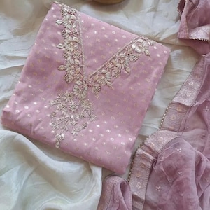 May include: A white ceramic mug with a black handle and the text "But First, Coffee" in a bold, black font. The mug is set against a blurred background, highlighting its simple design.