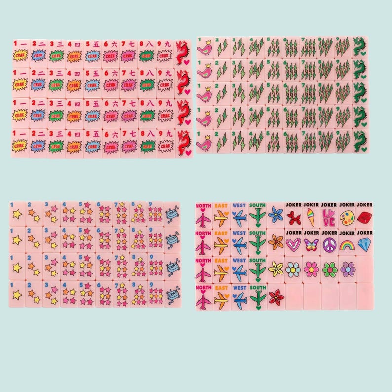 Pu&ograve; includere: Un set di tessere per mahjong rosa con varie grafiche colorate tra cui numeri, caratteri cinesi, fulmini, uccelli, stelle, aerei, fiori, cuori, arcobaleni e la parola JOKER stampata su tessere specifiche disposte in una griglia.