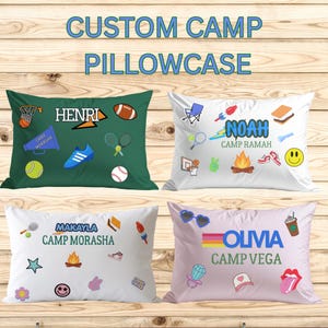 May include: Four rectangular pillowcases featuring custom names and camp-themed graphics. One is dark green with sports icons, while three are white or light purple with various illustrations including campfires, snacks, and accessories.