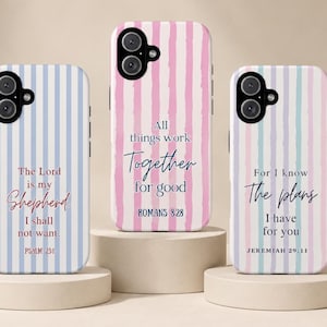 May include: Three smartphone cases featuring vertical stripes and religious text. The left case is blue-striped with Psalm 23:1. The center case is pink-striped with Romans 8:28. The right case is multi-colored striped with Jeremiah 29:11.