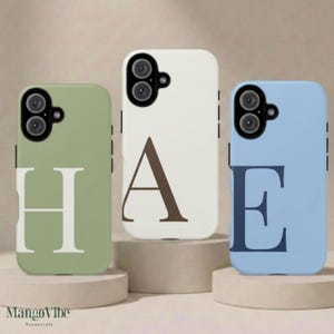 May include: Three smartphone cases featuring a matte finish. The left case is sage green with a large white letter H. The center case is off-white with a large brown letter A. The right case is light blue with a large dark blue letter E.