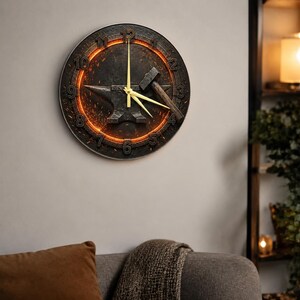May include: A circular wall clock with a blacksmith theme. The dark clock face has an orange glowing ring and features an anvil and hammer design. The clock hands are gold.