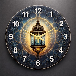 May include: Round wall clock with a blue and gold design. The clock face features a decorative lantern in the center, surrounded by a golden glow and Arabic numerals. The clock hands are gold.