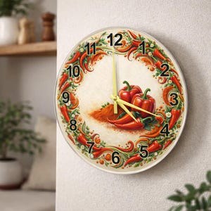 Könnte beinhalten: Eine runde Wanduhr mit einem Design aus roten Paprika und Chilischoten. Das Zifferblatt hat einen cremefarbenen Hintergrund mit einem Haufen rotem Chilipulver und drei roten Paprika. Die Zeiger der Uhr sind gelb.