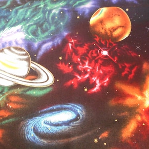 May include: A fabric design featuring a vibrant depiction of space. Planets, galaxies, and nebulae are rendered in shades of orange, red, blue, and green against a dark background. Stars and celestial bodies are scattered throughout.