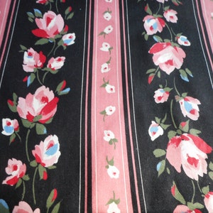May include: Black and pink striped fabric with a floral pattern of pink roses with white centers and blue accents.
