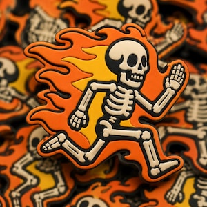 May include: A running skeleton figure with orange flames and a black outline. The skeleton is white with black details, and the flames are orange and yellow. The image is a Halloween-themed design.