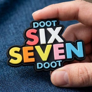 May include: A black rubberized patch featuring the text DOOT SIX SEVEN DOOT in raised, multi-colored lettering. The word SIX is in red and white, while the word SEVEN is in yellow, pink, and light blue. The word DOOT appears in light blue.
