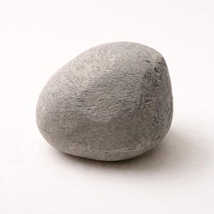 May include: A smooth, gray river rock with a rounded shape. The stone has a textured surface and varying shades of gray. The rock is a natural, organic shape, perfect for home decor or crafts.