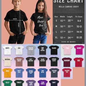 Op de afbeelding: Afbeelding van twee kinderen die zwarte t-shirts dragen, met een maattabel en kleuropties. De t-shirts hebben de tekst "Place Design Here". De maattabel toont de afmetingen in inches voor Bella Canvas 3001Y shirts.