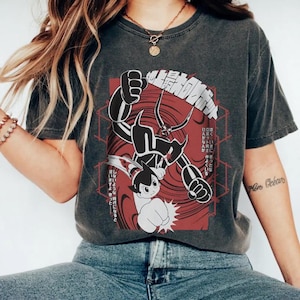 May include: Dark gray t-shirt featuring a Japanese anime-style graphic in black and red. The design includes a robot and a boy in a fighting pose, with Japanese text. The shirt is a vintage style.