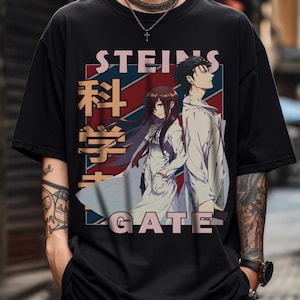 May include: Black t-shirt featuring anime characters and text. The design includes the words "STEINS GATE" in a stylized font, with Japanese characters and a red, white, and blue background.