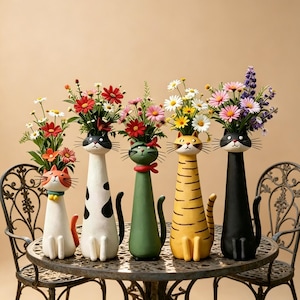 May include: Five cat-shaped vases, each with a unique design and color, hold colorful flowers. The vases are arranged on a round, wrought-iron table. The cat vases have different patterns and colors, including white, black, green, and yellow.