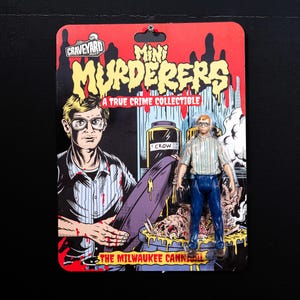 May include: A collectible action figure of "The Milwaukee Cannibal" from the "Mini Murderers" series. The figure is on a red and black card with the Graveyard Goods logo. The figure is wearing a striped shirt and blue pants.