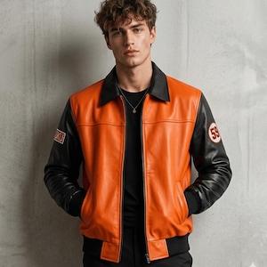 May include: An orange and black leather jacket with a black collar and sleeves. The jacket features a patch with the number 59 on the left sleeve and a small patch on the left chest. The jacket is worn over a black top.