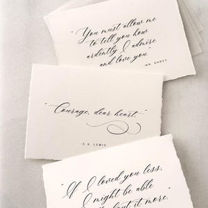 May include: Off-white paper cards with elegant calligraphy quotes from classic literature. The quotes include "You must allow me to tell you how ardently I admire and love you," "Courage, dear heart," and "If I loved you less, I might be able to talk about it more."