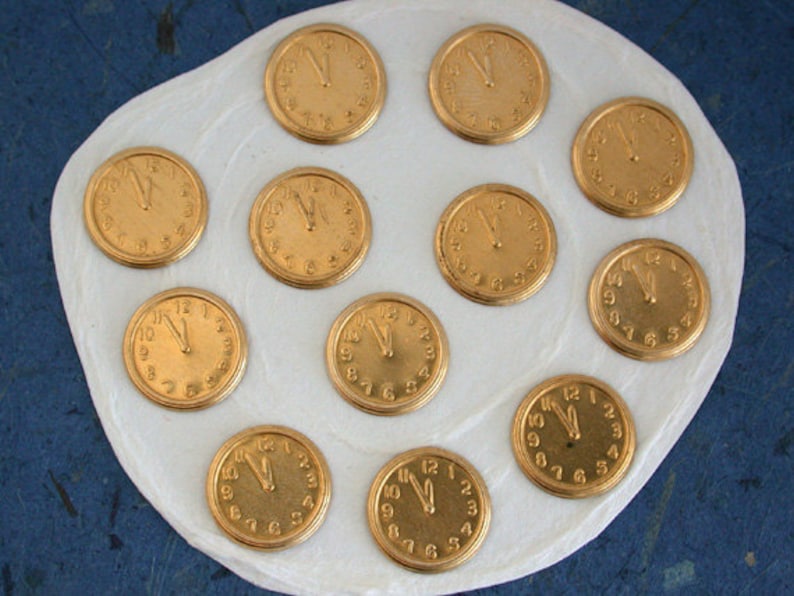 May include: A white surface with twelve gold-coloured clock faces, each with Roman numerals and black hands.