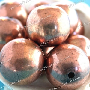 以下が含まれることがあります： 銅色の丸いビーズが10個あります。ビーズは滑らかで光沢があり、わずかに金属的な外観をしています。