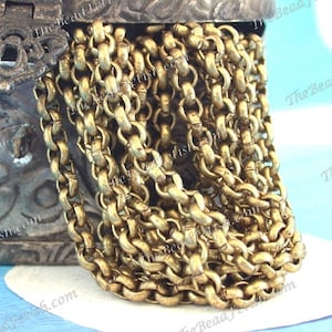 May include: A close-up of a gold chain necklace. The chain is made of thick, round links and has a slightly textured finish.