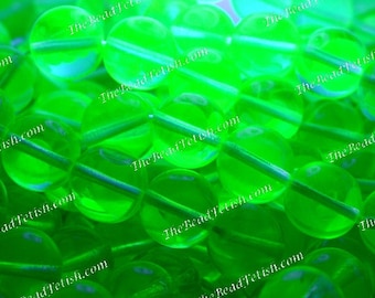May include: A close-up shot of bright green, translucent beads. Each bead is round with a central hole. The beads are strung together, creating a glowing effect. The text "The Bead Fetish.com" is visible in the image.