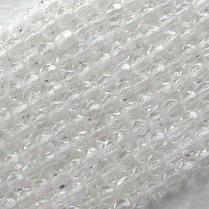 Puede incluir: Una hebra de cuentas de cristal facetadas transparentes. Las cuentas son peque&ntilde;as y redondas, con un acabado liso y pulido.
