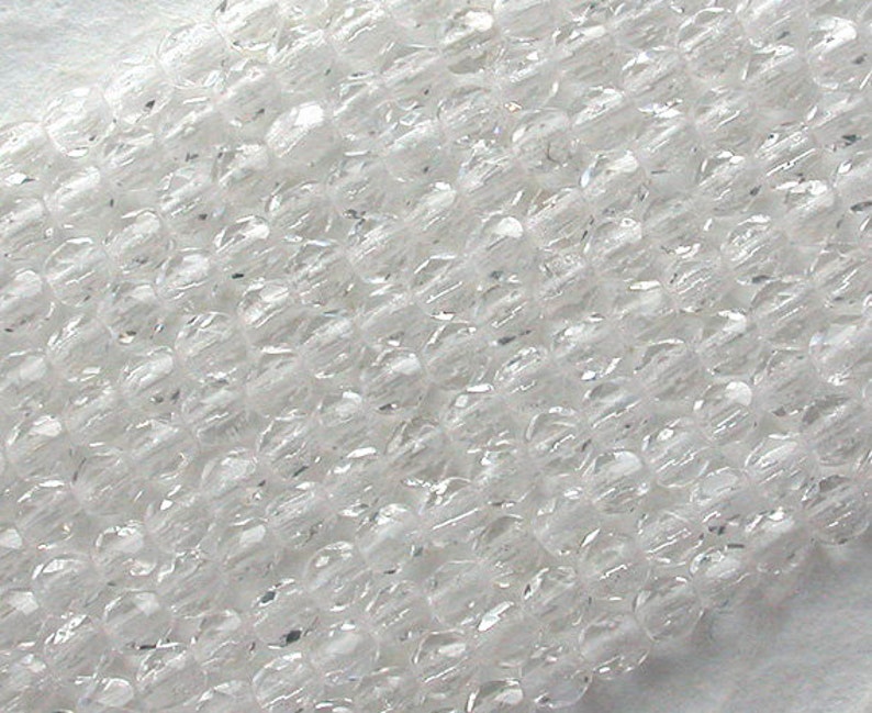 Puede incluir: Una hebra de cuentas de cristal facetadas transparentes. Las cuentas son peque&ntilde;as y redondas, con un acabado liso y pulido.