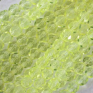 Puede incluir: Una hebra de cuentas de vidrio facetadas de color amarillo transl&uacute;cido. Las cuentas son redondas y tienen una forma ligeramente irregular. Est&aacute;n enhebradas en un hilo transparente.