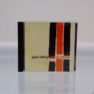 May include: A CD case featuring the album "City of Refuge" by John Fahey. The cover has a beige background with vertical black and orange stripes. The text "John Fahey" and "City of Refuge" are visible.