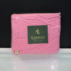 May include: A packaged pink and white striped flat sheet. The sheet is sealed in clear plastic. A green label with the text "RL LAUREN RALPH LAUREN ONE FULL FLAT SHEET" is attached to the sheet.