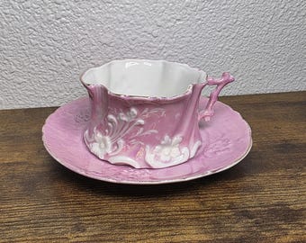 Pink lusterware porcelain teacup and saucer with raised floral design (lady's shaving mug)