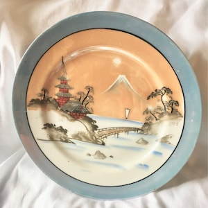 Placa de lustre japonés con pagoda, puente, barco y montaña