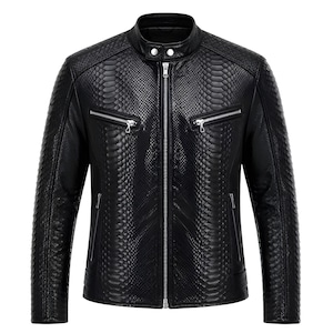 Peut inclure: Une veste noire avec un motif texturé en peau de serpent sur toute la surface. Le vêtement présente un col montant avec une fermeture à bouton-pression, une fermeture éclair frontale argentée et deux poches de poitrine zippées en métal argenté.