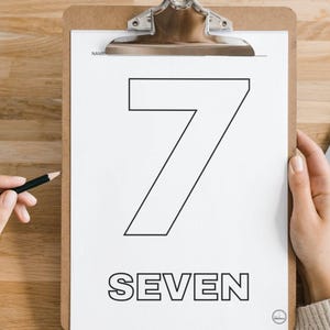 May include: A white sheet of paper in a clipboard features a large outline of the number seven and the word "SEVEN" below it. The clipboard is held by a person. A pencil is held in the other hand.