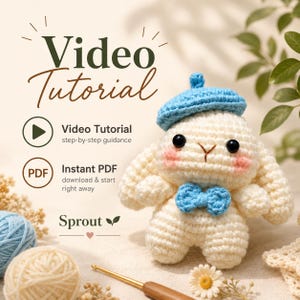 May include: A cream-coloured crocheted rabbit doll wearing a bright blue beret and a matching blue bow tie. The rabbit has black eyes and pink cheeks. Text on the image reads Video Tutorial, step-by-step guidance, Instant PDF, and Sprout.