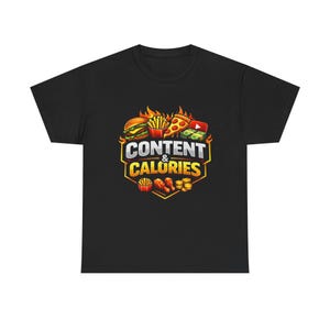 Op de afbeelding: Zwart t-shirt met een kleurrijke afbeelding van een hamburger, friet, pizza en geld, met de tekst "CONTENT & CALORIES" in een geel en oranje ontwerp. Het shirt is gemaakt van een zacht materiaal.
