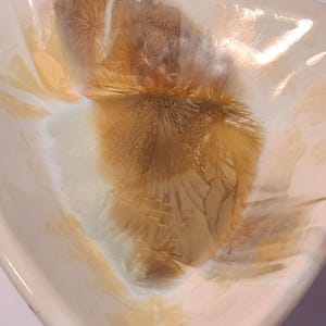 May include: A triangular ceramic bowl featuring a glossy white glaze with prominent crystalline formations in shades of amber and golden brown. The interior surface displays radiating starburst patterns that create a layered, textured appearance.