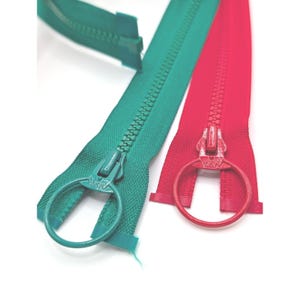 Puede incluir: Dos cremalleras de plástico, una de color verde azulado y otra de color rosa brillante, cada una con un tirador en forma de anillo grande. Los dientes y la cinta de la cremallera coinciden con el color del tirador y el logo YKK está grabado.