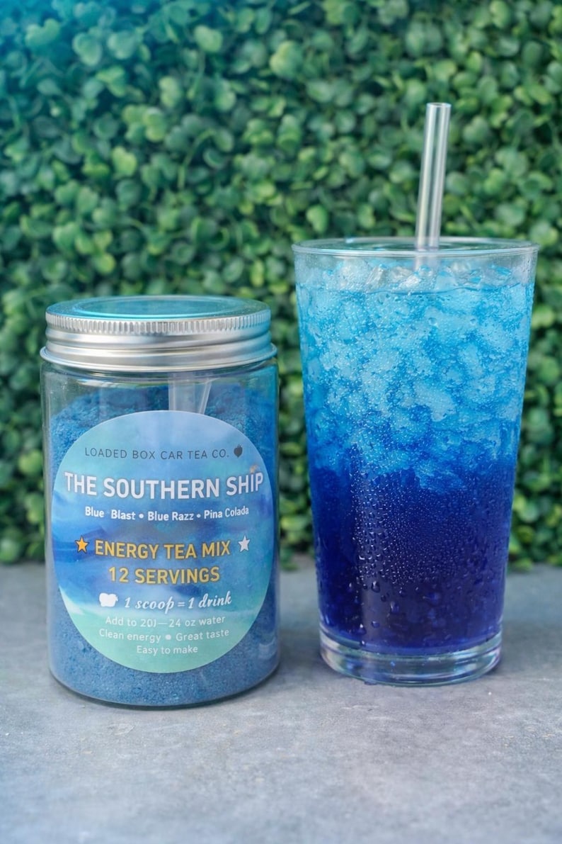 Op de afbeelding: Een pot blauwe energy-theemix en een glas blauwe drank met ijs. De pot heeft een label met de tekst "The Southern Ship Energy Tea Mix" met smaaknamen. De drank in het glas heeft een verloop van blauwtinten en een helder rietje.