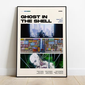 May include: A framed poster for the anime film "Ghost in the Shell" with a black frame. The poster features three vertical panels with scenes from the movie, the title, and the year 1995. The poster is on a light beige background.