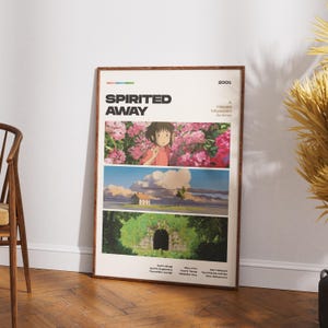 Op de afbeelding: Een ingelijste poster met de animatiefilm "Spirited Away". De poster heeft een cr&egrave;mekleurige achtergrond met drie panelen met sc&egrave;nes uit de film. Het bovenste paneel toont een meisje in een roze shirt tussen roze bloemen. De poster zit in een bruine lijst.