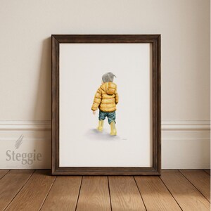 Puede incluir: Pintura a la acuarela de un niño con una chaqueta acolchada amarilla, vaqueros azules y botas de agua amarillas, alejándose. La obra de arte está enmarcada en un marco de madera marrón oscuro. La pintura está sobre un fondo blanco.